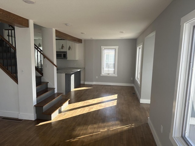 interior space featuring stairway, wood finished floors, and baseboards