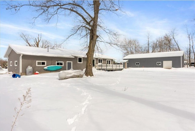 snow covered house with a wooden deck