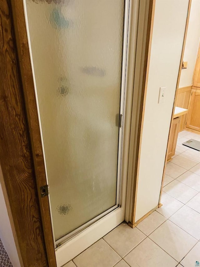 full bathroom with tile patterned flooring and a shower stall