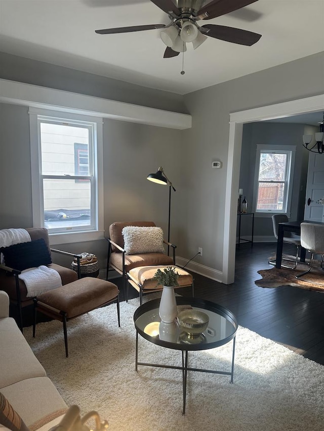 living room featuring wood finished floors, baseboards, and ceiling fan