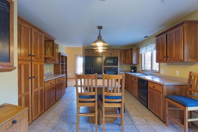 kitchen featuring light countertops, a sink, black appliances, and light tile patterned floors