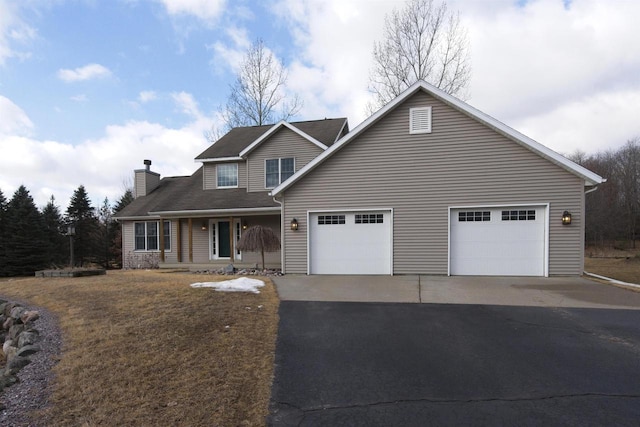 traditional home featuring driveway, a garage, and a chimney