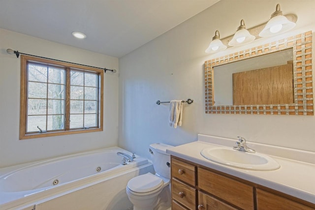 bathroom featuring a whirlpool tub, toilet, and vanity