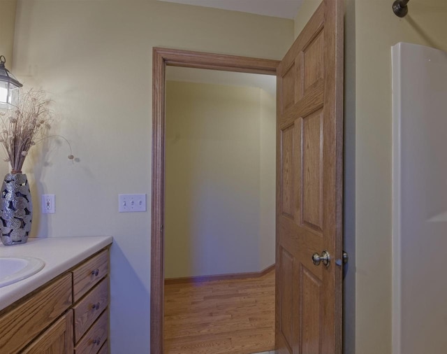 bathroom with vanity, baseboards, and wood finished floors