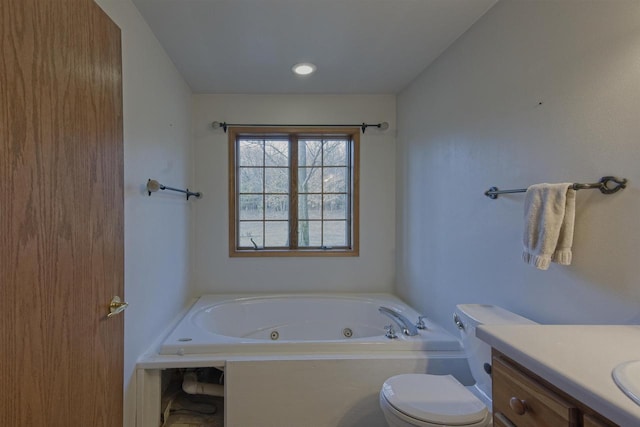 full bath with toilet, vanity, and a tub with jets