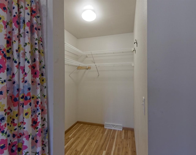 spacious closet with light wood-type flooring and visible vents