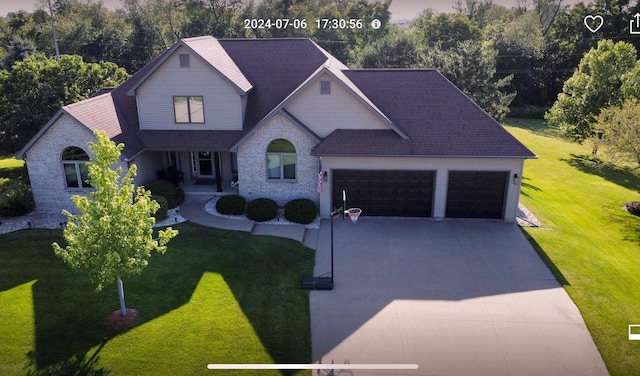 view of front of property featuring brick siding, a garage, concrete driveway, and a front yard