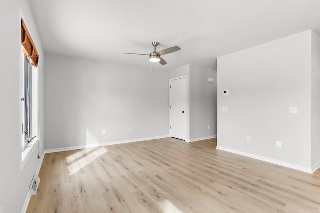 unfurnished room with ceiling fan, light wood-style flooring, and baseboards