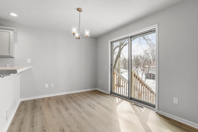 unfurnished dining area featuring recessed lighting, visible vents, light wood-style flooring, a chandelier, and baseboards