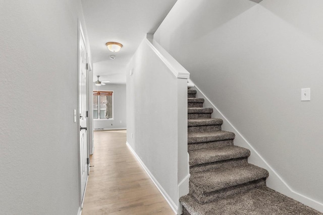 stairs featuring wood finished floors and baseboards