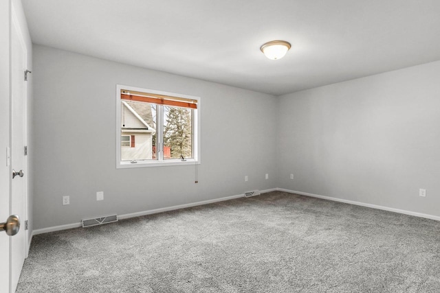 spare room featuring baseboards, visible vents, and carpet flooring