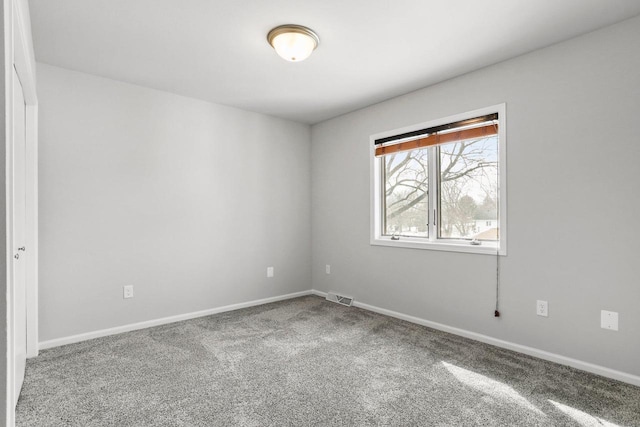 carpeted empty room with visible vents and baseboards