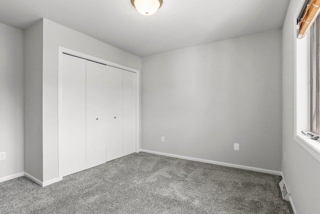 unfurnished bedroom with baseboards, a closet, visible vents, and carpet flooring