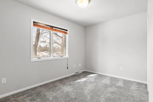 spare room featuring baseboards, visible vents, and carpet flooring