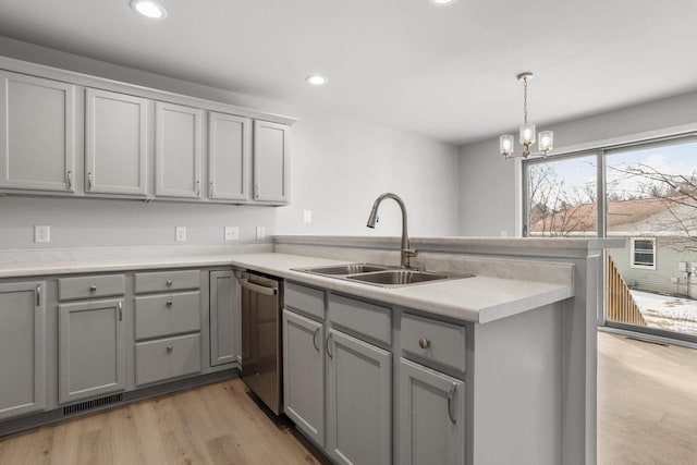 kitchen with dishwasher, a peninsula, gray cabinetry, light wood-style floors, and a sink