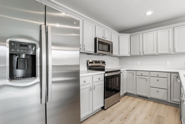 kitchen featuring recessed lighting, stainless steel appliances, visible vents, light countertops, and light wood finished floors