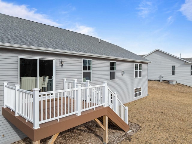 rear view of house with a shingled roof and a deck