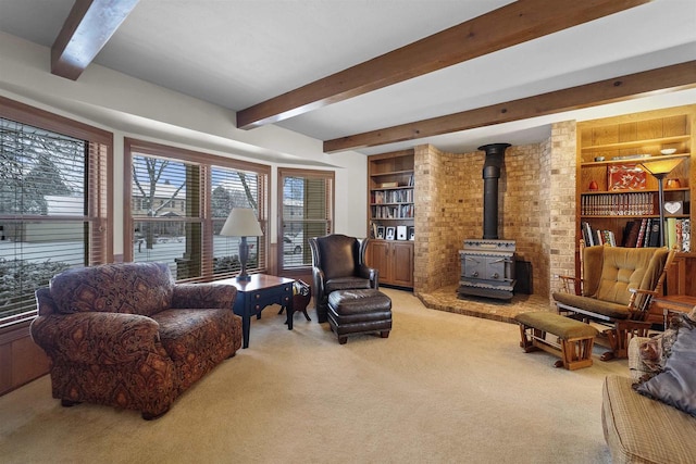 living area with a wood stove, carpet, built in features, and beam ceiling