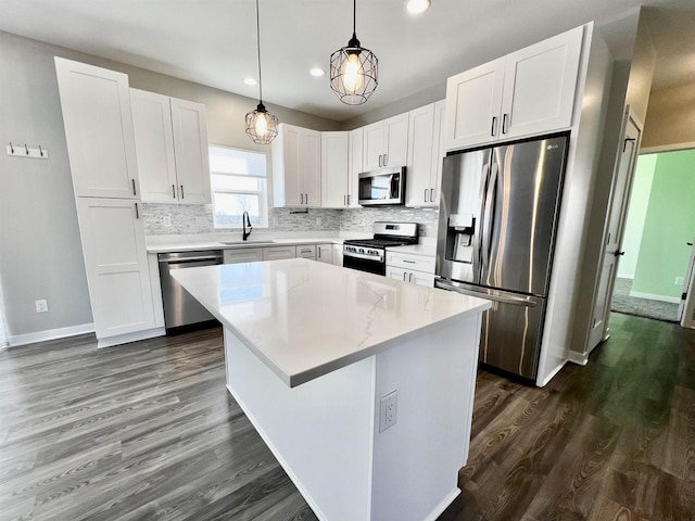 kitchen featuring a sink, white cabinetry, appliances with stainless steel finishes, decorative backsplash, and dark wood-style floors