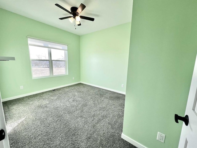 empty room with baseboards, dark colored carpet, and a ceiling fan