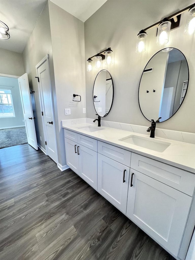 bathroom featuring double vanity, a sink, and wood finished floors