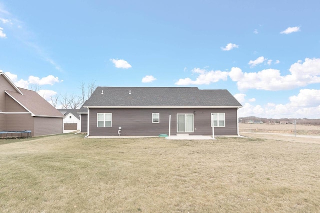 back of property featuring a trampoline, a patio area, and a lawn