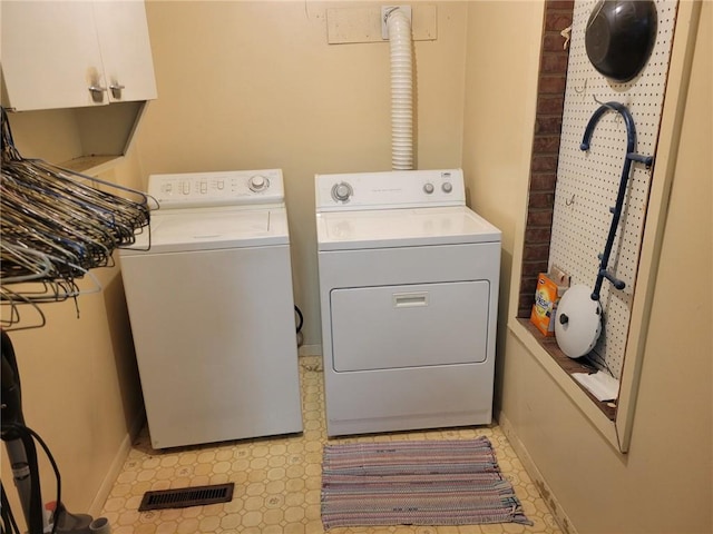 washroom with visible vents, baseboards, independent washer and dryer, cabinet space, and light floors