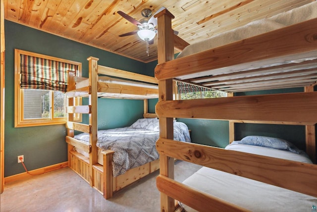 bedroom featuring concrete floors, wood ceiling, and baseboards