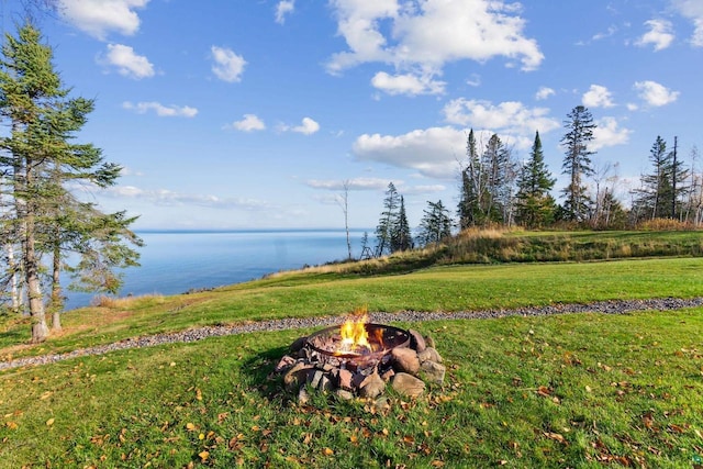 view of yard featuring a water view and an outdoor fire pit