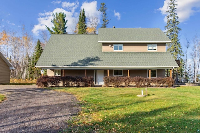 view of front of property featuring driveway, a shingled roof, a porch, and a front yard