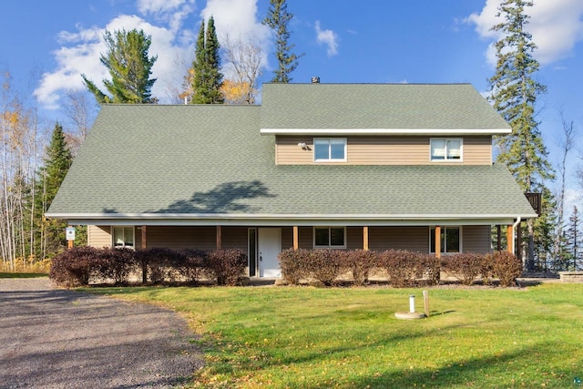 view of front of property featuring a shingled roof and a front yard