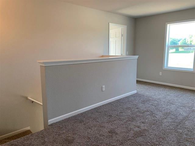 carpeted empty room featuring baseboards