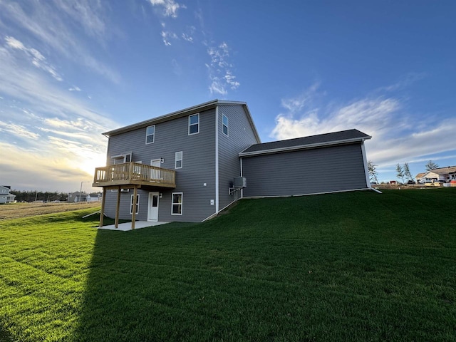 rear view of house with a deck, a yard, and a patio