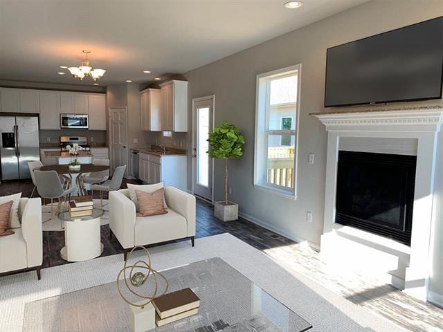 living area with a chandelier, recessed lighting, a fireplace, and baseboards