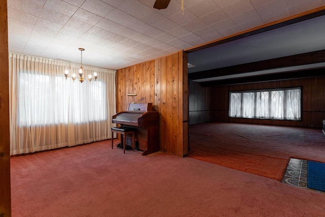 office with carpet, a healthy amount of sunlight, wooden walls, and ceiling fan with notable chandelier