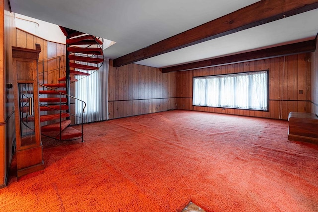 interior space featuring wood walls, stairway, carpet, and beam ceiling