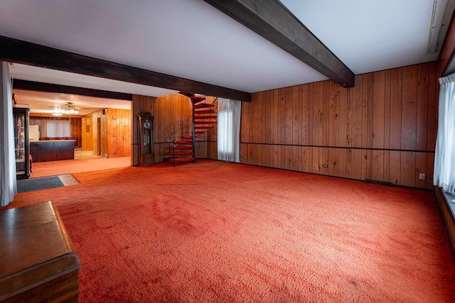 unfurnished living room with wooden walls, stairs, beamed ceiling, and carpet flooring