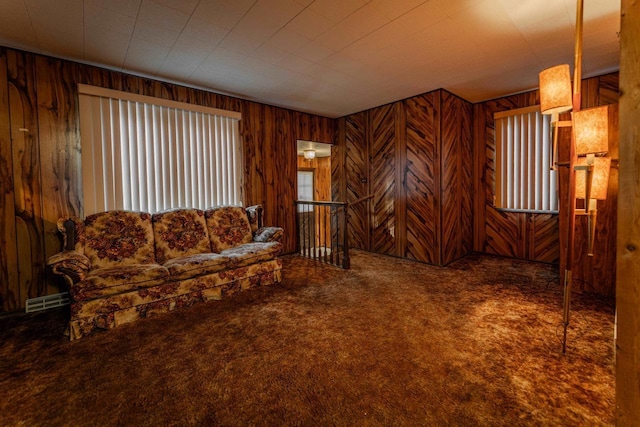 living room with carpet floors, visible vents, and wood walls