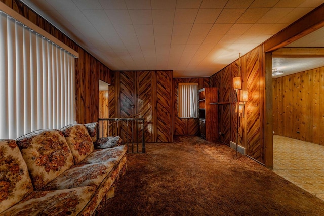 carpeted living area with wood walls