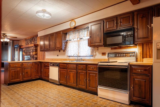 kitchen with black microwave, a peninsula, electric range, a sink, and light countertops