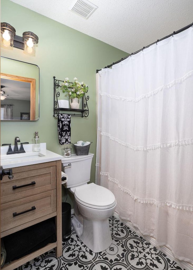 full bath featuring visible vents, toilet, a textured ceiling, vanity, and tile patterned flooring