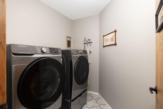 laundry area with laundry area, baseboards, a textured ceiling, and independent washer and dryer