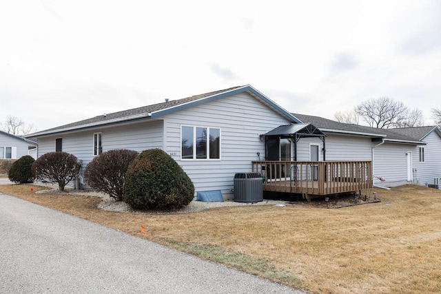 single story home featuring a deck, central AC, and a front yard