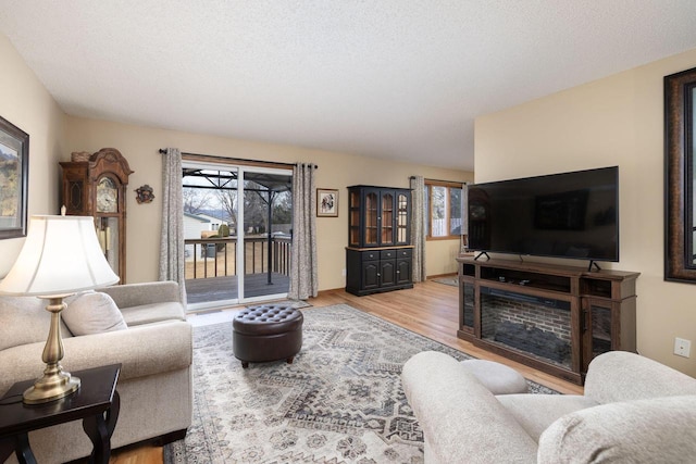 living area featuring a textured ceiling, wood finished floors, and a wealth of natural light