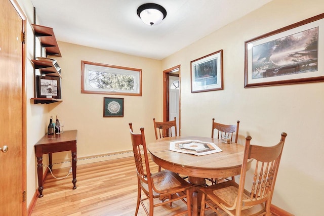 dining space with light wood finished floors, baseboards, and a baseboard radiator