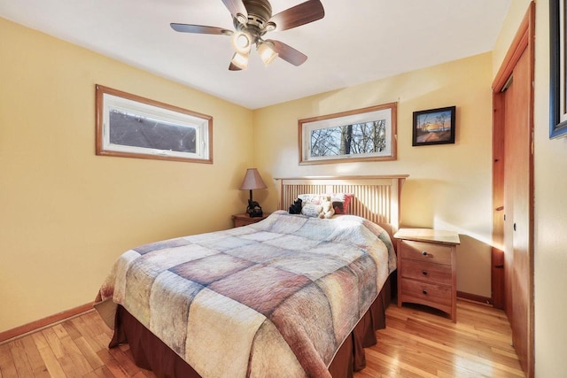 bedroom featuring light wood-type flooring, baseboards, and a ceiling fan