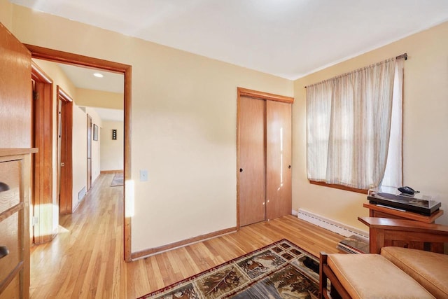 sitting room with light wood-style floors, baseboards, and baseboard heating