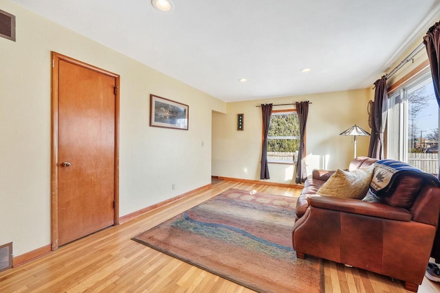 living room featuring recessed lighting, light wood-type flooring, and baseboards