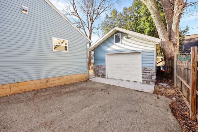 detached garage with driveway and fence