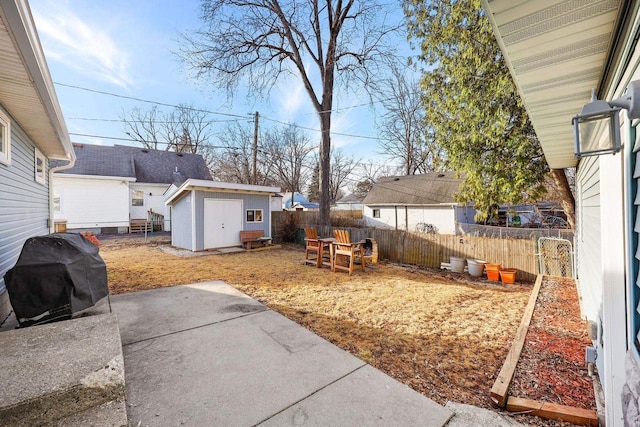 view of yard with an outbuilding, a fenced backyard, a storage shed, and a patio